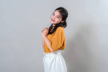 Genç bir kadının portresi, tatlı ve umut dolu bir gülümsemeyi, elleri çenesine kenetlenmiş, şefkatini ve minnettarlığını ifade ederken gri arka planda hafifçe eğilmiş bir şekilde gösteriyor..