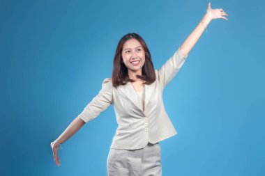 Endonezyalı kendine güvenen bir iş kadını kollarını açıp gülümserken resmi kurumsal kıyafetler giyerek küresel iş iletişimi için olumlu ve enerji ifade ediyor..