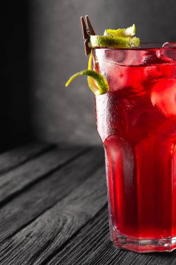 Alkolik, alkolsüz, siyah ahşap masada buzlu kırmızı kokteyl..