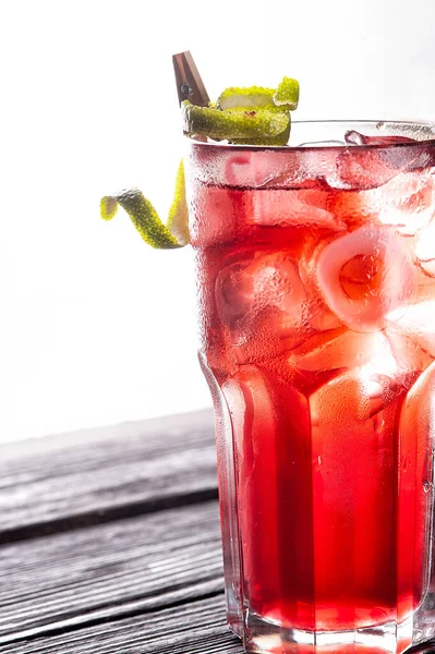 Cocktail rouge alcoolisé et non alcoolisé avec glace sur table en bois noir. — Photo