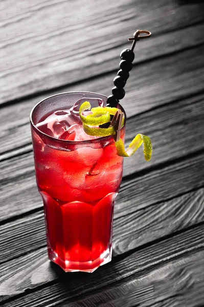 黒の木製のテーブルの上に氷とアルコールのない赤のカクテル. — ストック写真