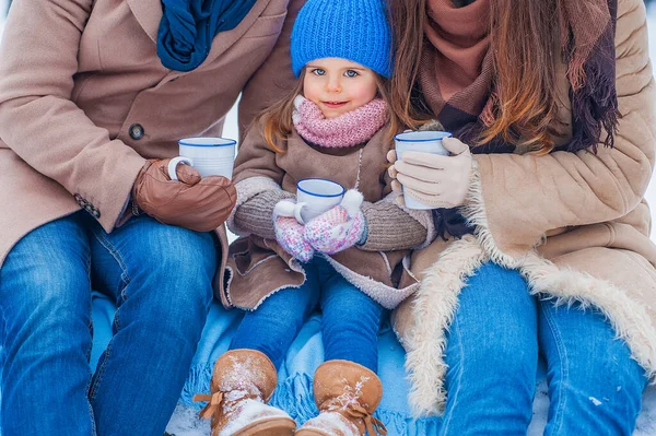 Portrait of a little girl, holding a cup, with parents, close-up — Photo
