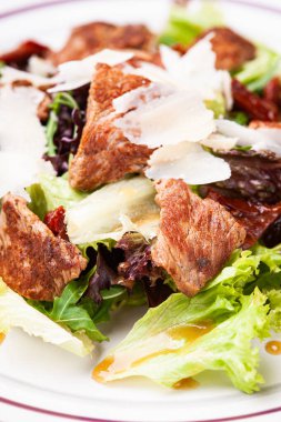 Beyaz tabakta eti olan taze salata.
