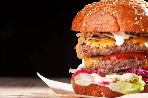 Restoranda siyah arkaplanda yakın plan hamburger.