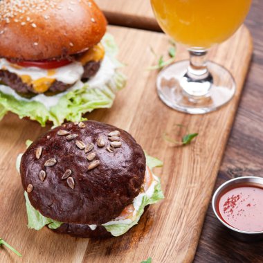 Hamburger ve bira ahşap masada.