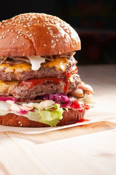 Sezamový hamburger na černém pozadí a dřevěný stůl — Stock fotografie