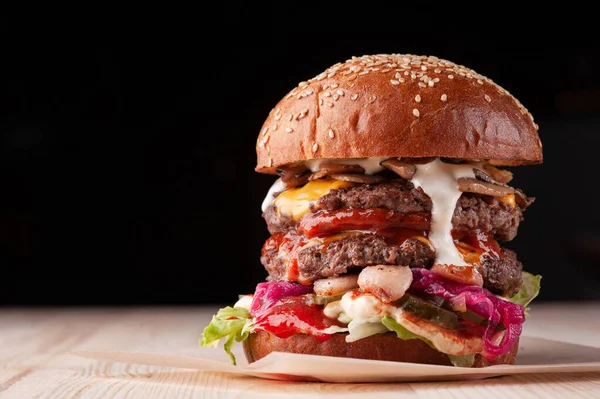 Restoranda siyah arka planda yakın plan burger.