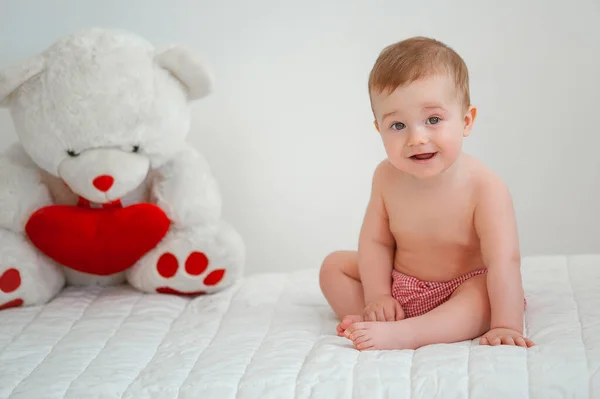 밝은 배경에 장난감 곰 이 있는 웃는 아이의 모습 스톡 사진