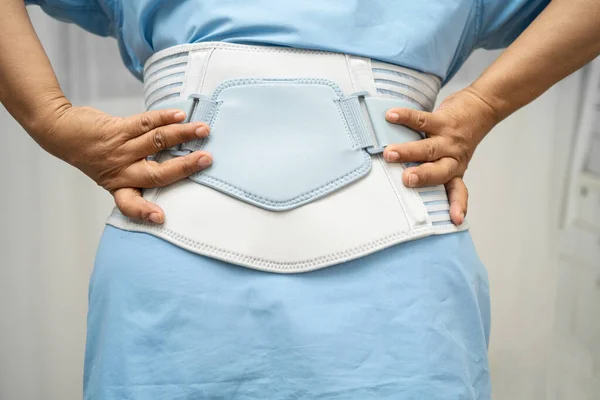 Asya baş ağrısı. Esnek destek kemeri takıp yürüteç takıyor..