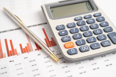 Veri iş grafikleri kağıdında kalemle hesap makinesi.