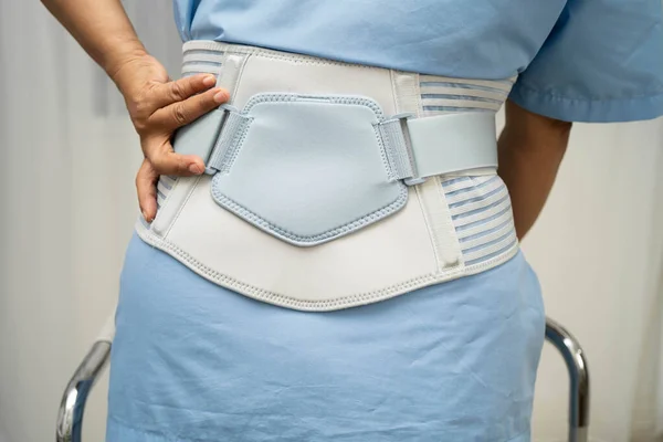 Asya baş ağrısı. Esnek destek kemeri takıp yürüteç takıyor..