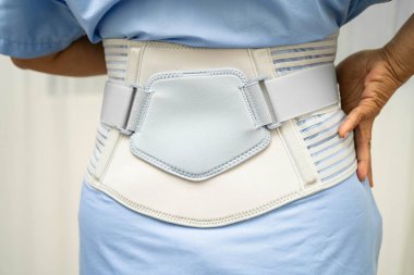 Asya baş ağrısı. Esnek destek kemeri takıp yürüteç takıyor..