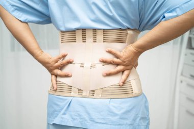 Asya baş ağrısı. Esnek destek kemeri takıp yürüteç takıyor..