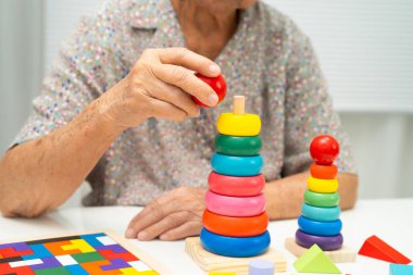 Asyalı yaşlı kadın oyun oynuyor.