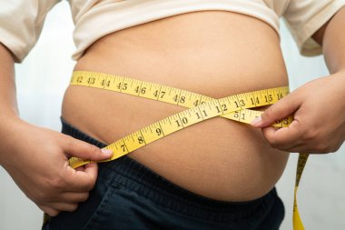 Şişman göbekli, kilolu, kilolu ve mezuralı Asyalı bir kadın..