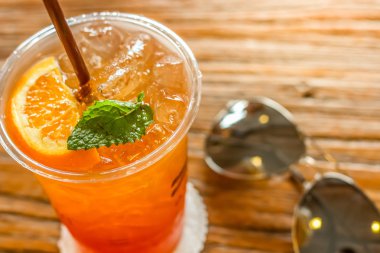 turuncu ve güzel doku arka plan sıcak ışık ile güneş gözlüğü ile dekore edilmiş kahverengi kabuğu üstüne nane limon buz çay