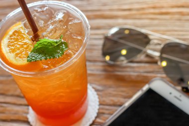 turuncu ve güzel doku arka plan sıcak ışık ile güneş gözlüğü ile dekore edilmiş kahverengi kabuğu üstüne nane limon buz çay