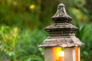 taş fener lamba ampul içinde yeşil bahçe orman ortamında ile