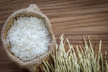 kulak pirinç, isolaed ahşap doku arka plan üzerinde olan torba pirinç yasemin bol