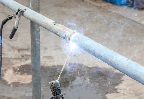 Fechar o trabalhador de construção usando a soldagem de topo um tubo — Fotografia de Stock