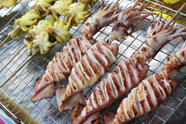 Varios calamares a la parrilla en la bandeja en el mercado para la venta — Foto de Stock