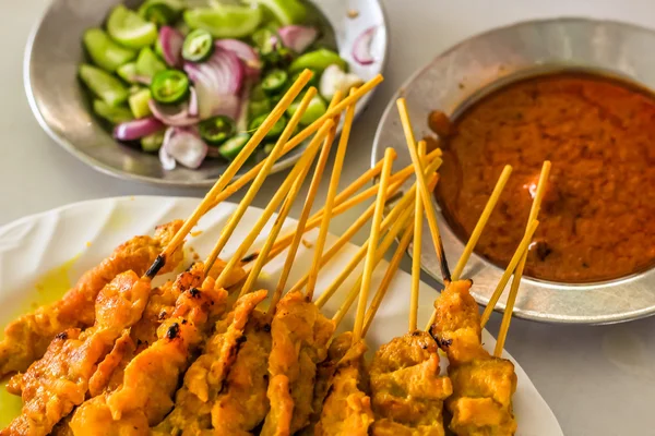 Hermosos satays de cerdo con guarniciones listas para comer al estilo tailandés — Foto de Stock