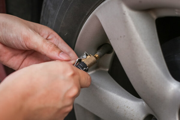 Filling air into a grungy car tire to increase pressure