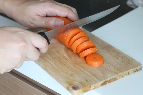 Chef mano usó su cuchillo picando zanahoria en una tabla de madera — Foto de Stock