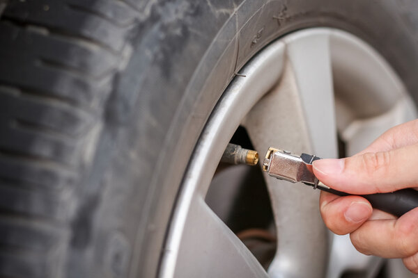 Filling air into a grungy car tire to increase pressure
