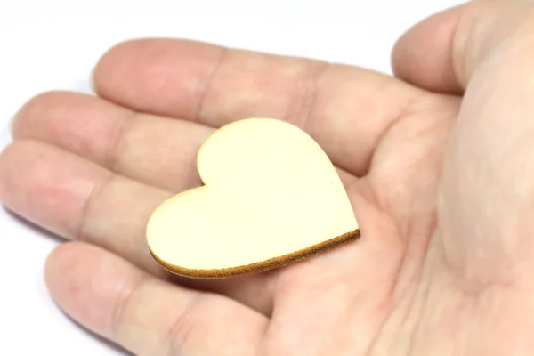 Feche a mão macro man segurando coração de madeira, símbolo de amor no fundo branco com foco seletivo na forma do coração — Fotografia de Stock