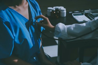 healthy concept; Doctor checking patient's heart with stethoscope at a hospital