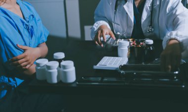 Elinde ilaç şişesi olan kadın doktor hastanın yan etkileri için ilaç kalitesini kontrol ediyor ve hasta bilgilerini hastanede kaydediyor. tıbbi ve sağlık hizmetleri kavramı