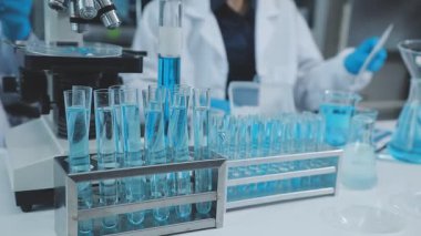 Laboratuarda çalışan koruyucu gözlüklü ve eldivenli bilim adamı.