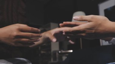 Birbirini seven genç bir çift kafede el ele tutuşuyor.