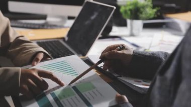 İş adamı ve kadın dizüstü bilgisayar ve belgelerle çalışıyor.