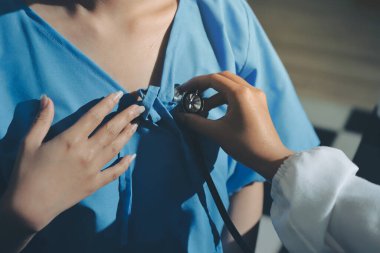 healthy concept; Doctor checking patient's heart with stethoscope at a hospital
