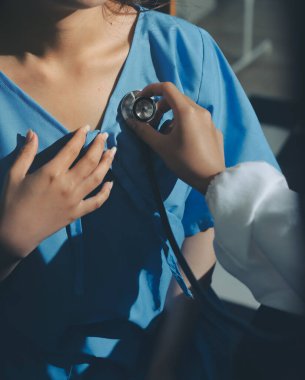 healthy concept; Doctor checking patient's heart with stethoscope at a hospital