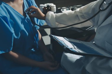 healthy concept; Doctor checking patient's heart with stethoscope at a hospital