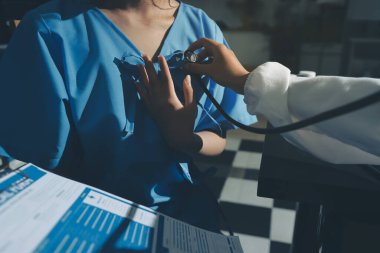 healthy concept; Doctor checking patient's heart with stethoscope at a hospital