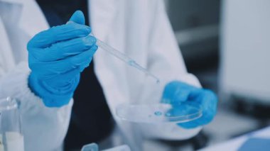 Bilim adamı laboratuarda sıvı tüpü tutuyor.