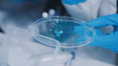 Laboratuvarda pipetle çalışan bir bilim adamına yakın plan..