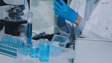 Kimyasal ekipmanlarla çalışan laboratuvar asistanı, kapatın.