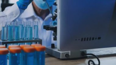 Laboratuvarda test tüpleri üzerinde çalışan bir bilim adamı.