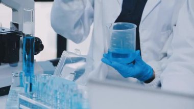 Laboratuvarda deney tüpüyle çalışan bir laboratuvar asistanı.