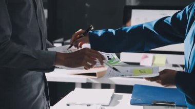 Yakın plan - erkek ellerinin kalem tutması ve ofisteki modern bir ofiste notlar yazması