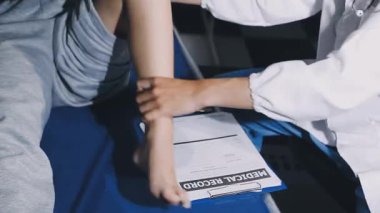 Doktor bir hastane koğuşunda hastanın tansiyonunu ölçüyor..