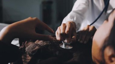 Hastanedeki hastasının kalbini muayene eden doktor..