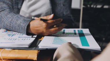 İş yerindeki kanepede oturan takım elbiseli ve gözlüklü genç iş adamı dizüstü bilgisayarla çalışıyor..