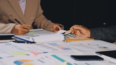 İş adamları mali tabloları ve raporları ofiste tartışıyor..