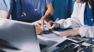 Hastanede bilgisayar ve dijital tabletle çalışan bir doktor..